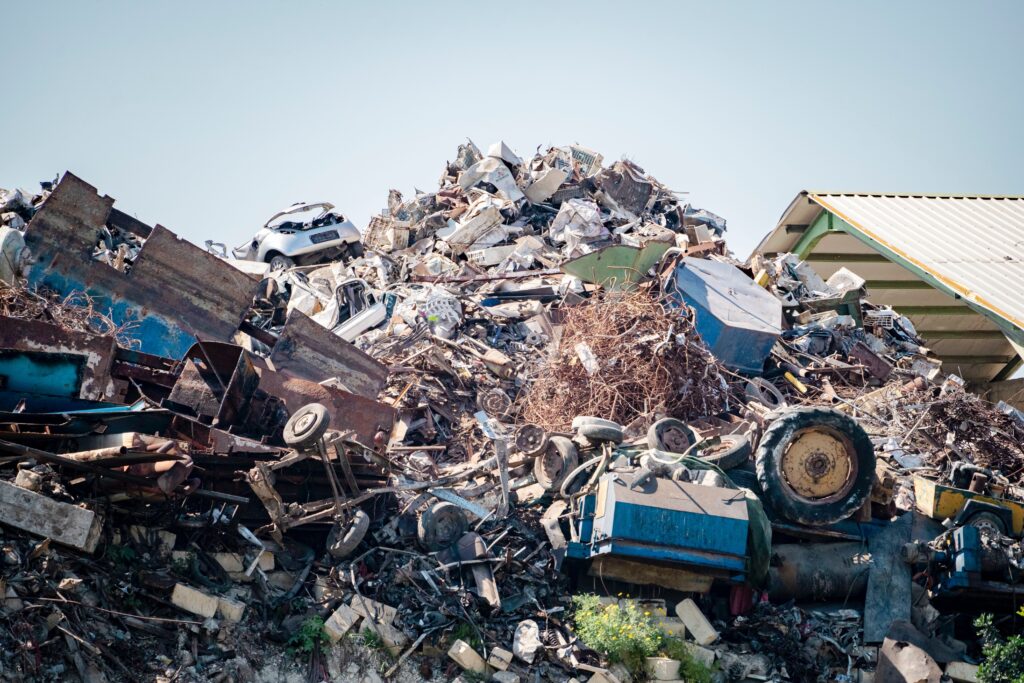 pile of junk vehicles, including car bodies and tires in a scrapyard
